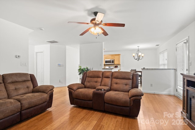9236 Clifton Meadow Dr, Matthews, NC 28105 - living area featuring a chandelier, light wood-type flooring, ceiling fan, and a tile fireplace