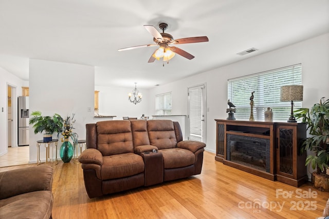 9236 Clifton Meadow Dr, Matthews, NC 28105 - living room featuring a ceiling fan, a chandelier, and light wood-type flooring