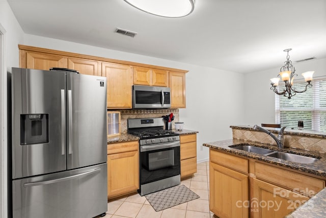 9236 Clifton Meadow Dr, Matthews, NC 28105 - kitchen with stainless steel appliances, backsplash, light tile patterned floors, dark stone counters, and a chandelier
