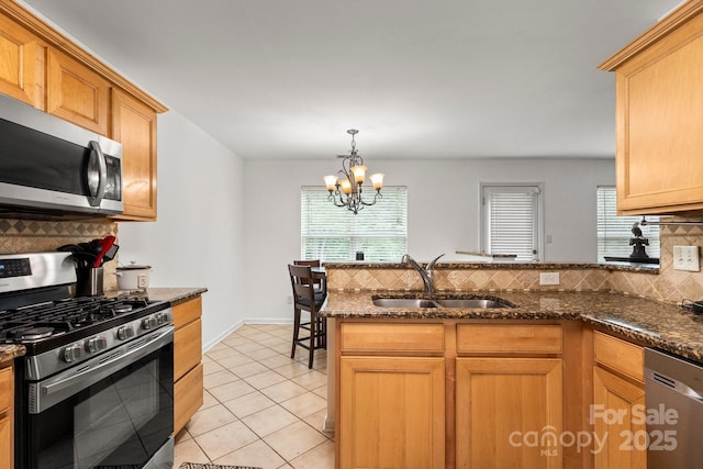 9236 Clifton Meadow Dr, Matthews, NC 28105 - kitchen featuring stainless steel appliances, decorative backsplash, dark stone countertops, and a peninsula
