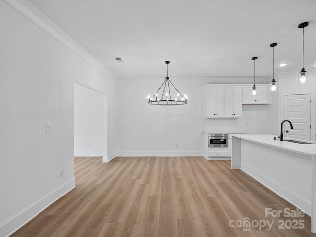 8303 Adrian Ct, Charlotte, NC 28270 - unfurnished dining area featuring a sink, light wood-type flooring, a chandelier, baseboards, and ornamental molding