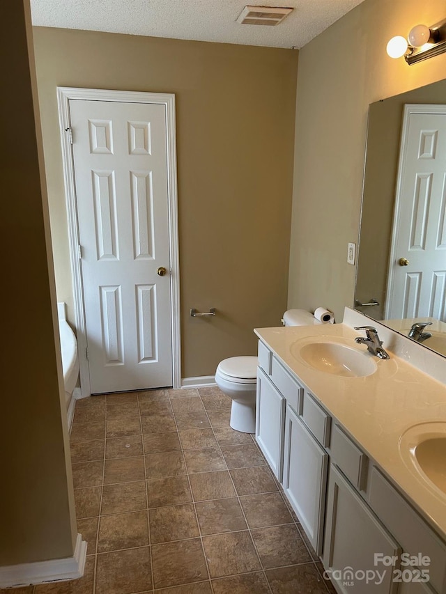 8125 Weeping Fig Ln, Charlotte, NC 28215 - bathroom featuring double vanity and a textured ceiling