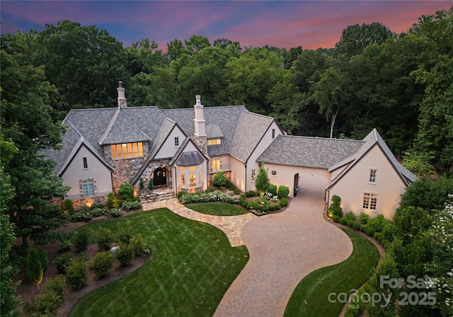8500 Longview Club Dr, Waxhaw, NC 28173 - view of front of house featuring stone siding, stucco siding, a chimney, a front yard, and french doors