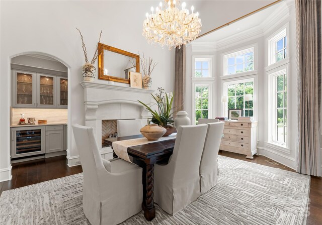 8500 Longview Club Dr, Waxhaw, NC 28173 - dining room with beverage cooler, ornamental molding, dark wood-style flooring, a chandelier, and a bar
