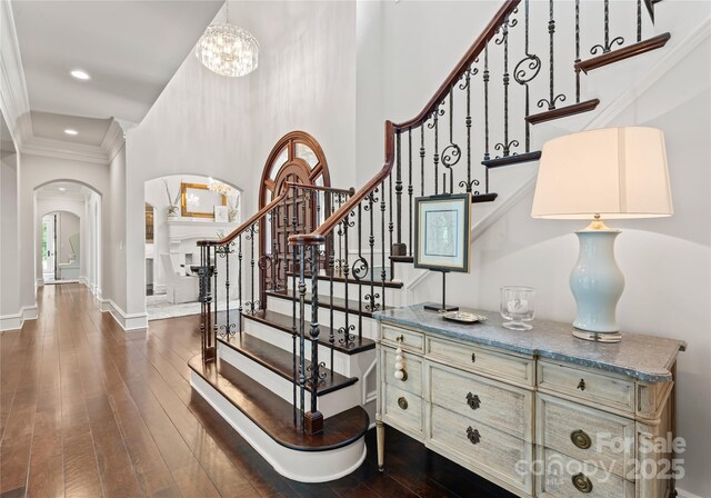 8500 Longview Club Dr, Waxhaw, NC 28173 - stairway featuring arched walkways, crown molding, hardwood / wood-style floors, recessed lighting, and a chandelier