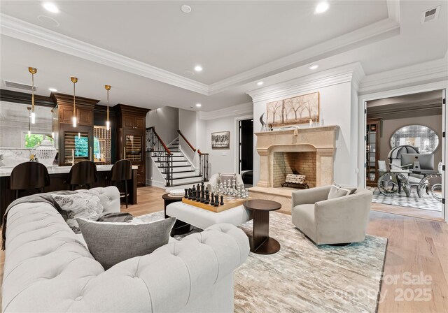 8500 Longview Club Dr, Waxhaw, NC 28173 - living room with a fireplace, light wood-style floors, a tray ceiling, stairway, and recessed lighting