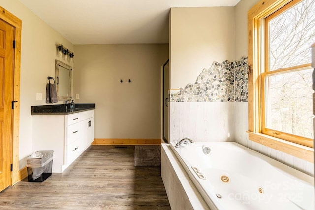 720 Cane Creek Rd, Fletcher, NC 28732 - bathroom featuring vanity, a jetted tub, wood finished floors, baseboards, and a shower