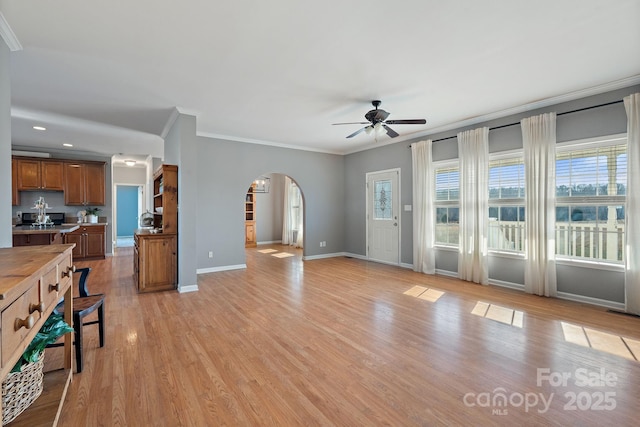 1285 Waitman Rd, Lexington, NC 27295 - unfurnished living room featuring arched walkways, ceiling fan, ornamental molding, baseboards, and light wood-style flooring