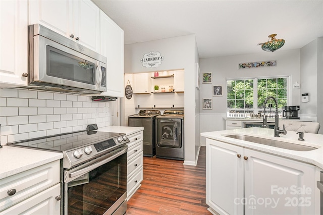 108 Shade Tree Cir, Fort Mill, SC 29715 - kitchen featuring appliances with stainless steel finishes, washer and dryer, dark wood-style floors, and white cabinetry