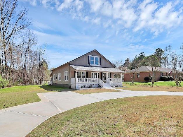 12300 Caldwell Rd, Charlotte, NC 28213 - view of front facade featuring covered porch, driveway, and a front lawn