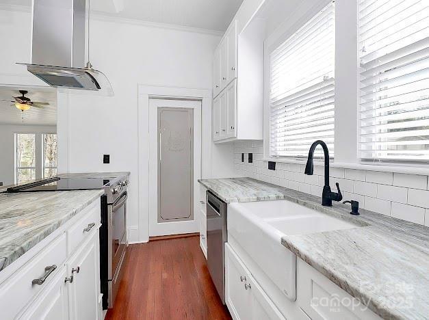 12300 Caldwell Rd, Charlotte, NC 28213 - kitchen featuring appliances with stainless steel finishes, range hood, white cabinetry, ceiling fan, and ornamental molding