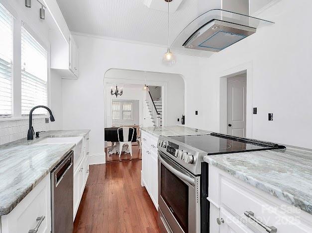 12300 Caldwell Rd, Charlotte, NC 28213 - kitchen with appliances with stainless steel finishes, ventilation hood, dark wood finished floors, light stone countertops, and healthy amount of natural light