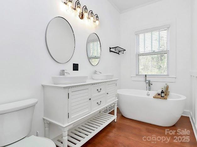 12300 Caldwell Rd, Charlotte, NC 28213 - bathroom with double vanity, a freestanding tub, and wood finished floors