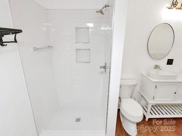 12300 Caldwell Rd, Charlotte, NC 28213 - full bath featuring a tile shower, vanity, and wood finished floors