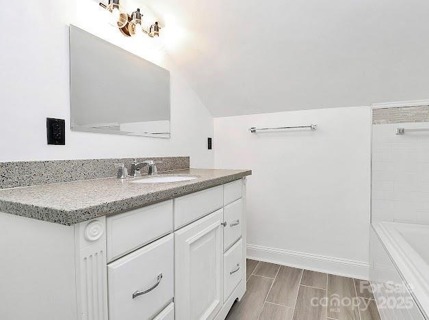12300 Caldwell Rd, Charlotte, NC 28213 - bathroom featuring vanity, a tub, lofted ceiling, and wood finished floors