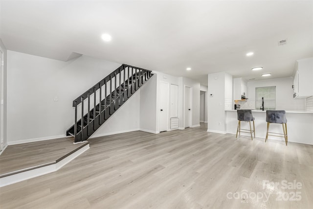 3941 Briarhill Dr, Charlotte, NC 28215 - unfurnished living room with stairway, light wood finished floors, baseboards, and recessed lighting