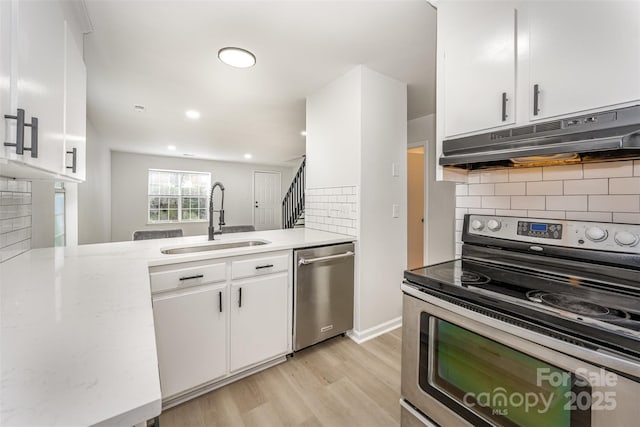 3941 Briarhill Dr, Charlotte, NC 28215 - kitchen featuring stainless steel appliances, a sink, under cabinet range hood, white cabinets, and light wood-style flooring