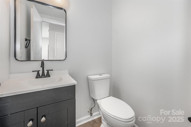 3941 Briarhill Dr, Charlotte, NC 28215 - bathroom with baseboards, vanity, toilet, and wood finished floors