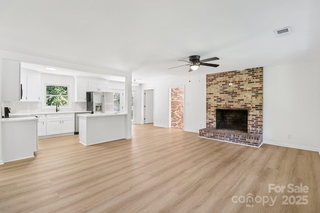 848 Ike Lynch Rd, Dallas, NC 28034 - unfurnished living room with ceiling fan, light wood-style floors, and a brick fireplace