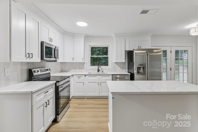 848 Ike Lynch Rd, Dallas, NC 28034 - kitchen with stainless steel appliances, light countertops, tasteful backsplash, and white cabinetry