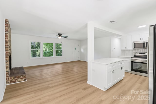 848 Ike Lynch Rd, Dallas, NC 28034 - kitchen with appliances with stainless steel finishes, ceiling fan, light wood-style floors, and white cabinetry