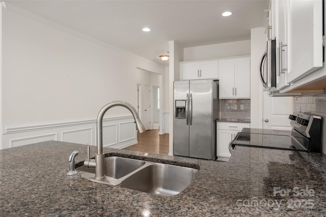 10410 Bradstreet Commons Way, Charlotte, NC 28215 - kitchen with stainless steel appliances, tasteful backsplash, white cabinetry, dark stone countertops, and ornamental molding