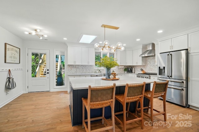 10043 Tepa Pl, Tega Cay, SC 29708 - kitchen with high end fridge, wall chimney range hood, tasteful backsplash, light countertops, and white cabinetry