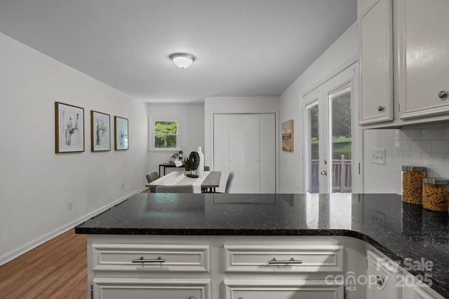 146 Duff St, Gastonia, NC 29715 - kitchen with a peninsula, wood finished floors, tasteful backsplash, dark stone countertops, and white cabinets