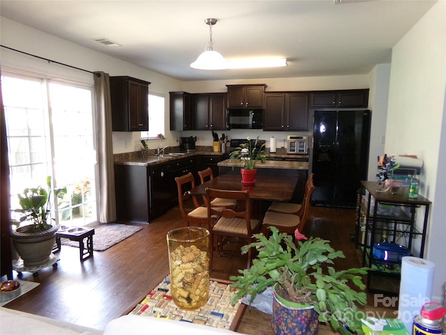 1818 Windy Willow Ln, Dallas, NC 28034 - kitchen with black appliances, dark wood-style flooring, dark brown cabinets, decorative light fixtures, and a center island