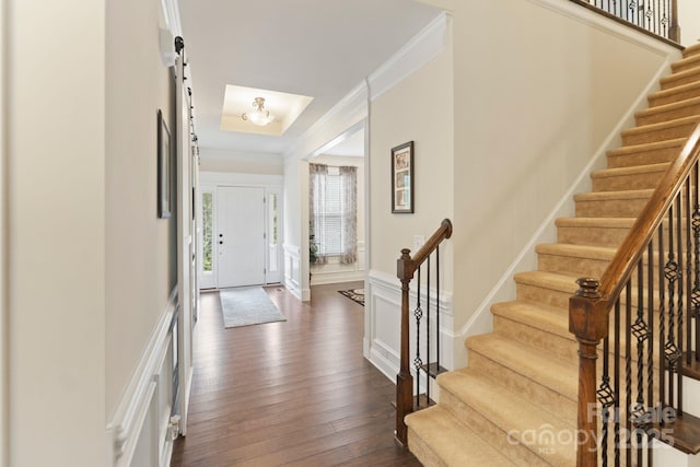 274 Cove Creek Loop, Mooresville, NC 28117 - entryway with crown molding, stairs, dark wood-style flooring, a decorative wall, and a barn door