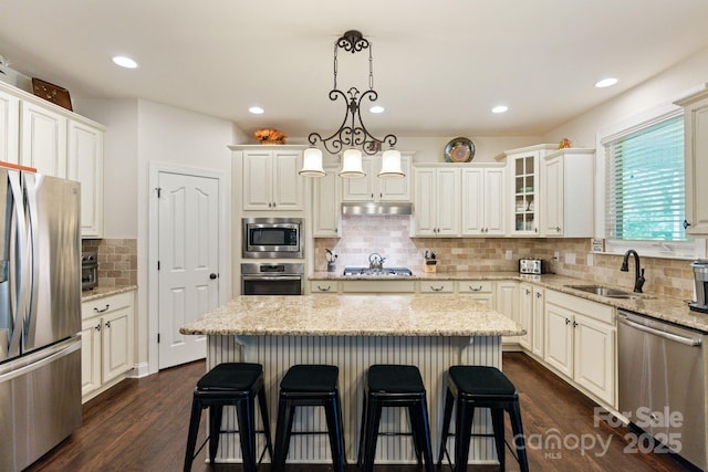 274 Cove Creek Loop, Mooresville, NC 28117 - kitchen featuring stainless steel appliances, under cabinet range hood, a breakfast bar area, backsplash, and a center island