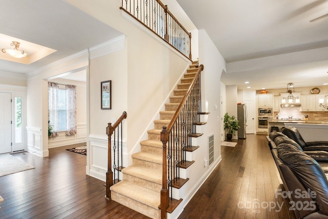 274 Cove Creek Loop, Mooresville, NC 28117 - foyer entrance featuring dark wood finished floors, stairway, a wainscoted wall, crown molding, and recessed lighting