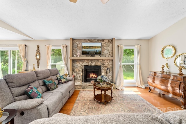 10951 Fox Mill Ln, Charlotte, NC 28277 - living room with wood finished floors, a textured ceiling, a stone fireplace, and ceiling fan