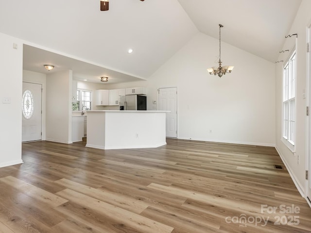 7006 Lone Eagle Dr # 18, Monroe, NC 28110 - unfurnished living room featuring high vaulted ceiling, a chandelier, ceiling fan, and light wood-style floors