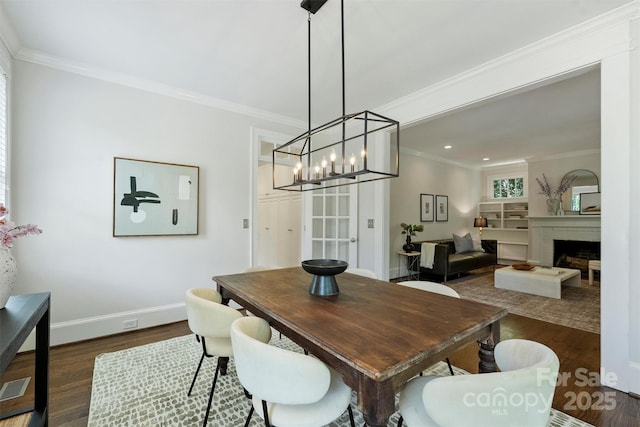 2223 Club Rd, Charlotte, NC 28205 - dining space featuring dark wood-type flooring, a chandelier, crown molding, recessed lighting, and a brick fireplace
