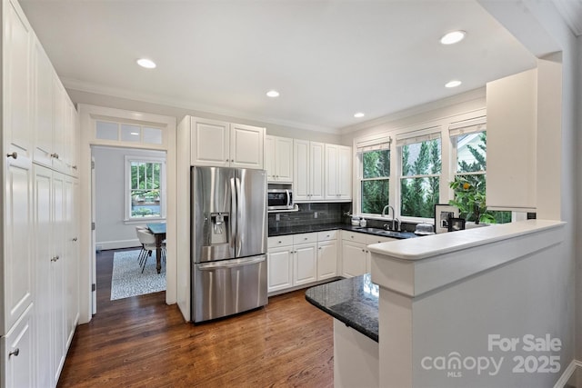2223 Club Rd, Charlotte, NC 28205 - kitchen featuring stainless steel appliances, dark wood-style floors, crown molding, white cabinetry, and tasteful backsplash