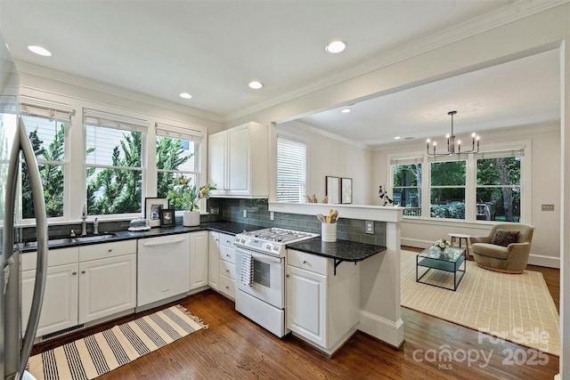 2223 Club Rd, Charlotte, NC 28205 - kitchen with white appliances, a peninsula, dark countertops, a chandelier, and white cabinets