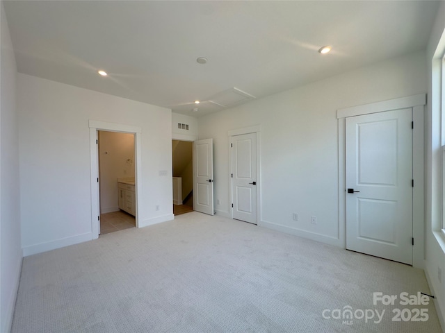 3618 S Tryon St Unit 19, Charlotte, NC 28217 - unfurnished bedroom featuring light colored carpet, baseboards, recessed lighting, ensuite bathroom, and two closets
