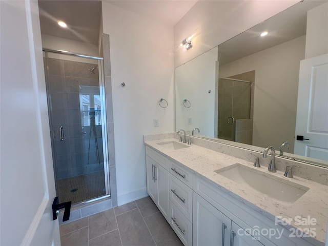 3618 S Tryon St Unit 19, Charlotte, NC 28217 - bathroom with double vanity, a shower stall, tile patterned flooring, and recessed lighting