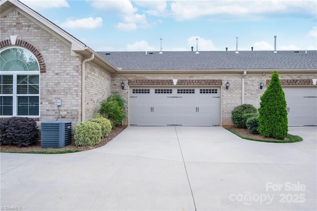 202 Watchtower Ct, Winston Salem, NC 27127 - view of front of property featuring brick siding, driveway, central AC unit, an attached garage, and a shingled roof