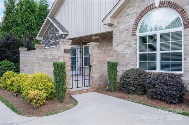 202 Watchtower Ct, Winston Salem, NC 27127 - view of exterior entry with a ceiling fan, a gate, and board and batten siding