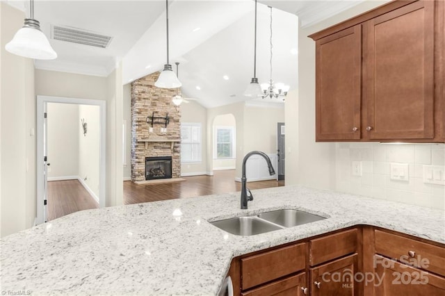 202 Watchtower Ct, Winston Salem, NC 27127 - kitchen featuring a sink, wood finished floors, light stone counters, a fireplace, and ornamental molding