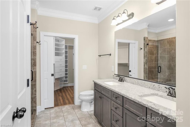 202 Watchtower Ct, Winston Salem, NC 27127 - bathroom with a walk in closet, double vanity, a stall shower, crown molding, and toilet