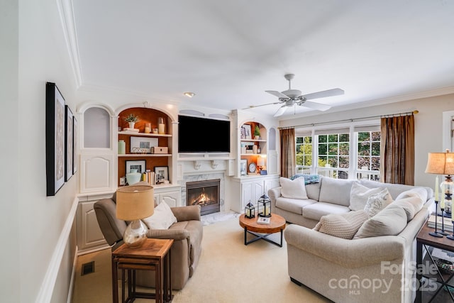 10127 Tallent Ln, Huntersville, NC 28078 - living area featuring crown molding, a ceiling fan, a fireplace, built in features, and light colored carpet