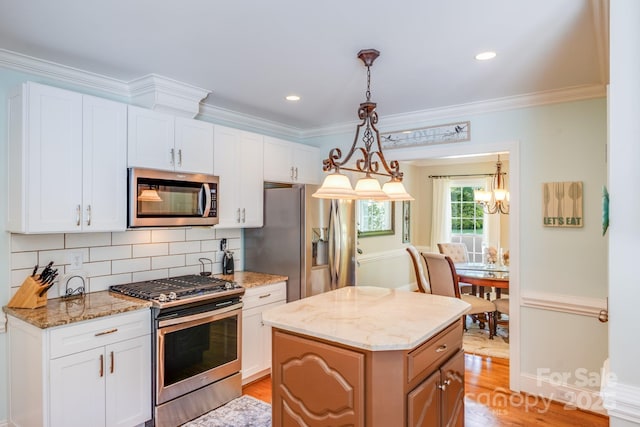 10127 Tallent Ln, Huntersville, NC 28078 - kitchen with stainless steel appliances, backsplash, white cabinets, light stone countertops, and light wood-type flooring