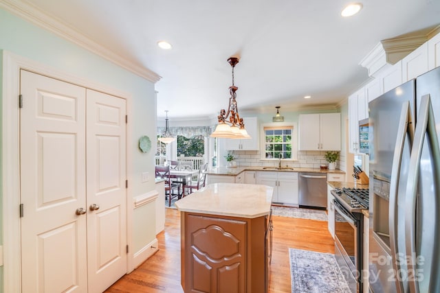 10127 Tallent Ln, Huntersville, NC 28078 - kitchen featuring appliances with stainless steel finishes, ornamental molding, a kitchen island, tasteful backsplash, and white cabinets