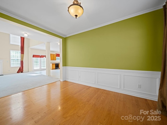 5921 Firethorne Ln, Concord, NC 28025 - unfurnished room with ornamental molding, wainscoting, wood finished floors, and a fireplace