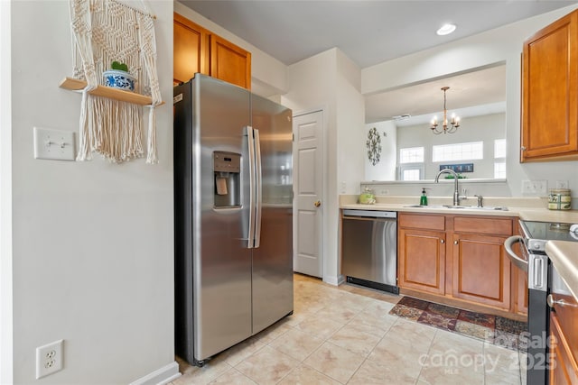 1418 Skidaway St NW Unit 427, Concord, NC 28027 - kitchen featuring appliances with stainless steel finishes, a chandelier, brown cabinetry, light countertops, and light tile patterned floors