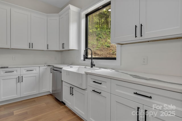 127 View Ridge Parkway, Leicester, NC 28748 - kitchen with stainless steel dishwasher, white cabinets, light stone counters, and light wood-style flooring