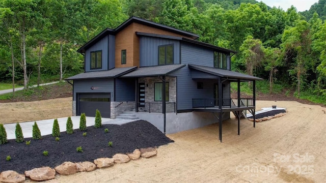 127 View Ridge Parkway, Leicester, NC 28748 - modern home with a porch, an attached garage, stone siding, a view of trees, and driveway
